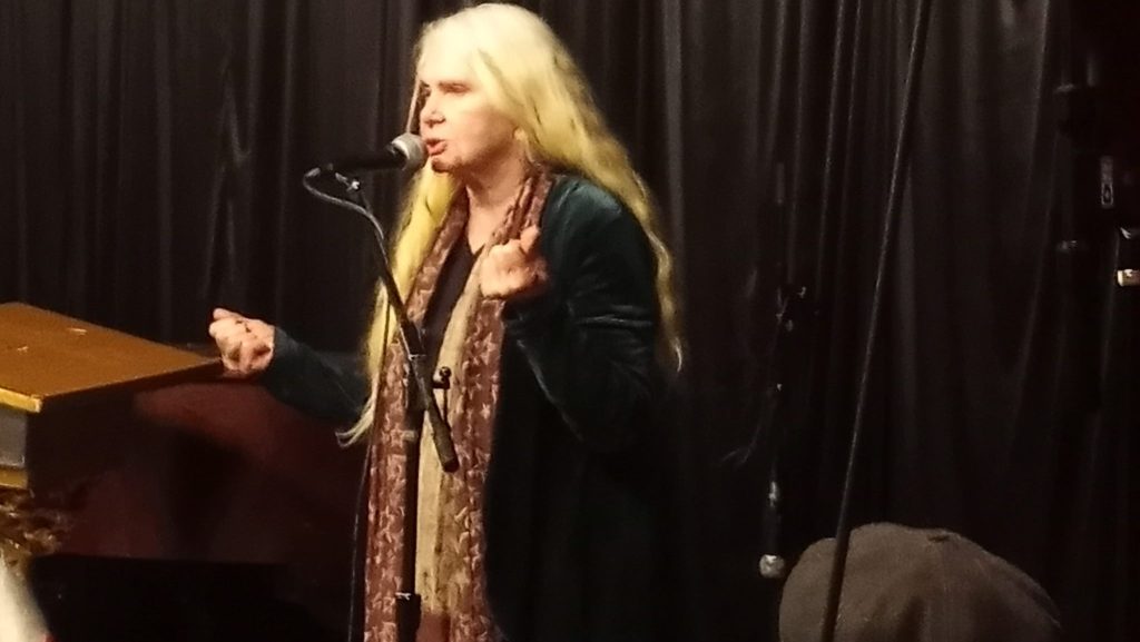 Marilyn Megnity, former owner of Mercury Cafe, reads poetry at an open mic