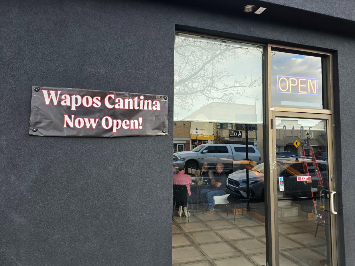 Wapos Cantina Now Open sign on a black building