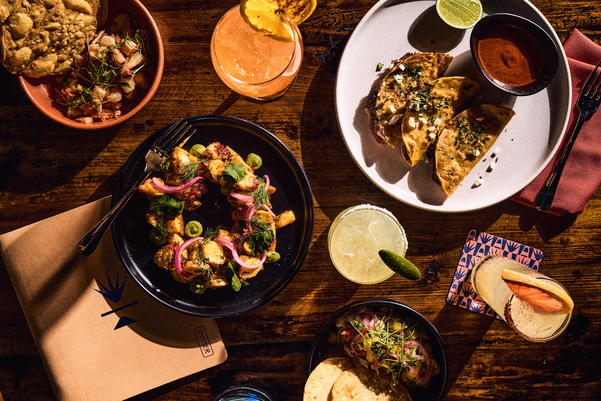 variety of Mexican dishes and cocktails on a table
