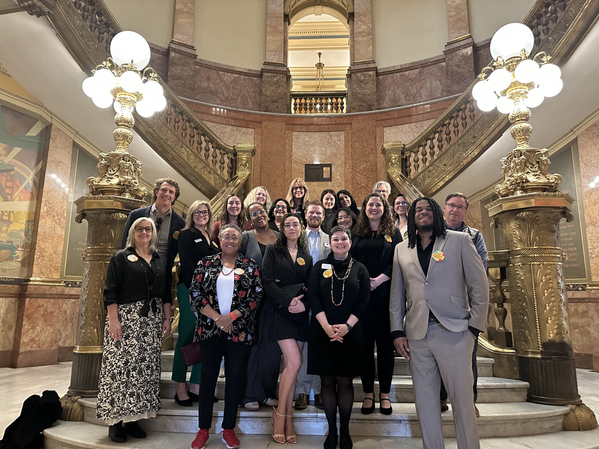 A group of people stand on the steps of the Capitol after March was made Arts Education Month.