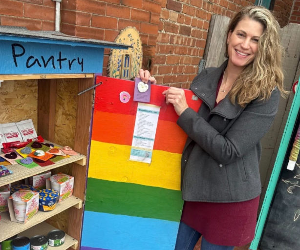 woman standing next to an open fridge