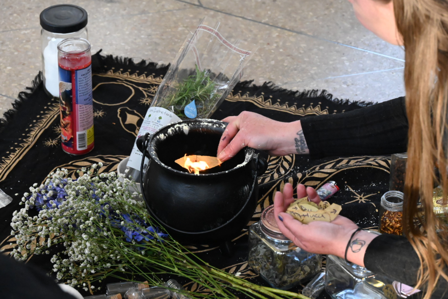women burns herbs during a ritual at Cheesman Park in Denver