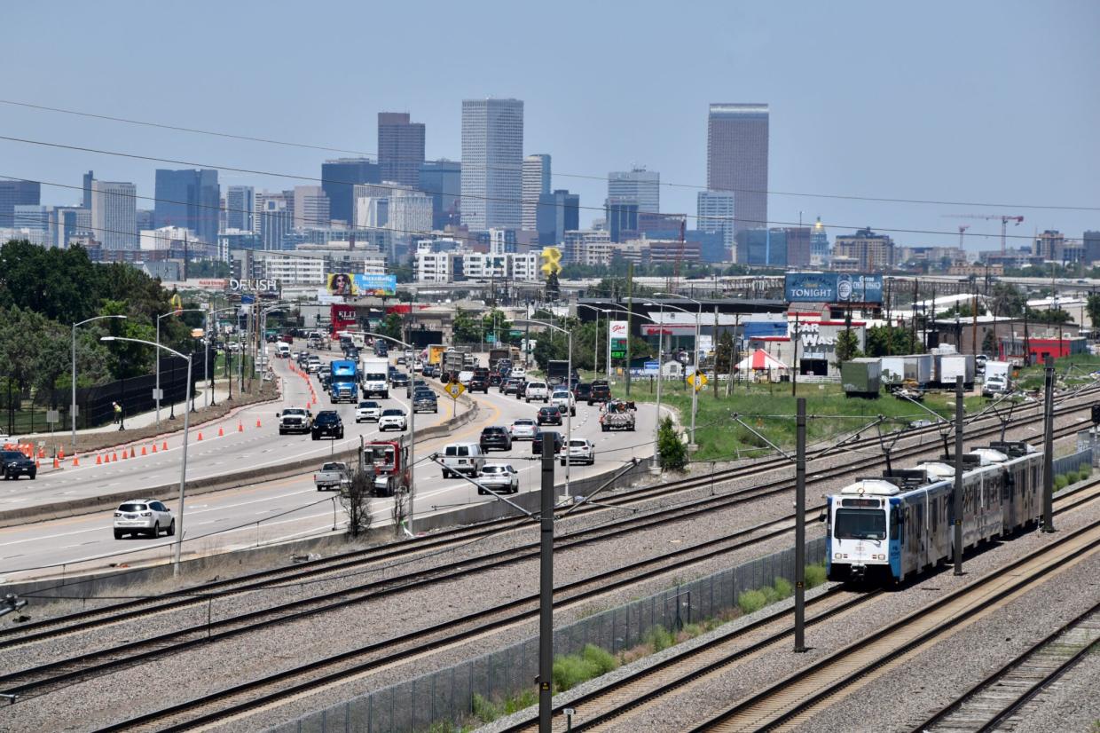 A view of the Denver skyline as a light rail car goes by on Santa Fe Avenue.