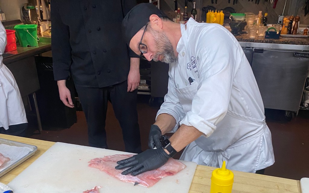 a man cutting fish.