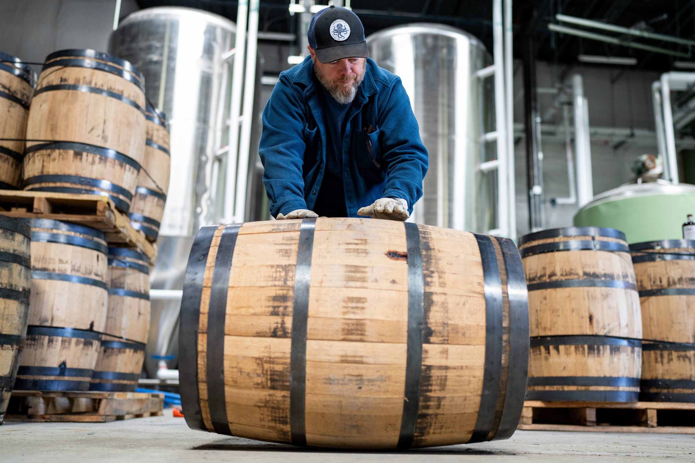 man pushing a barrel of whiskey