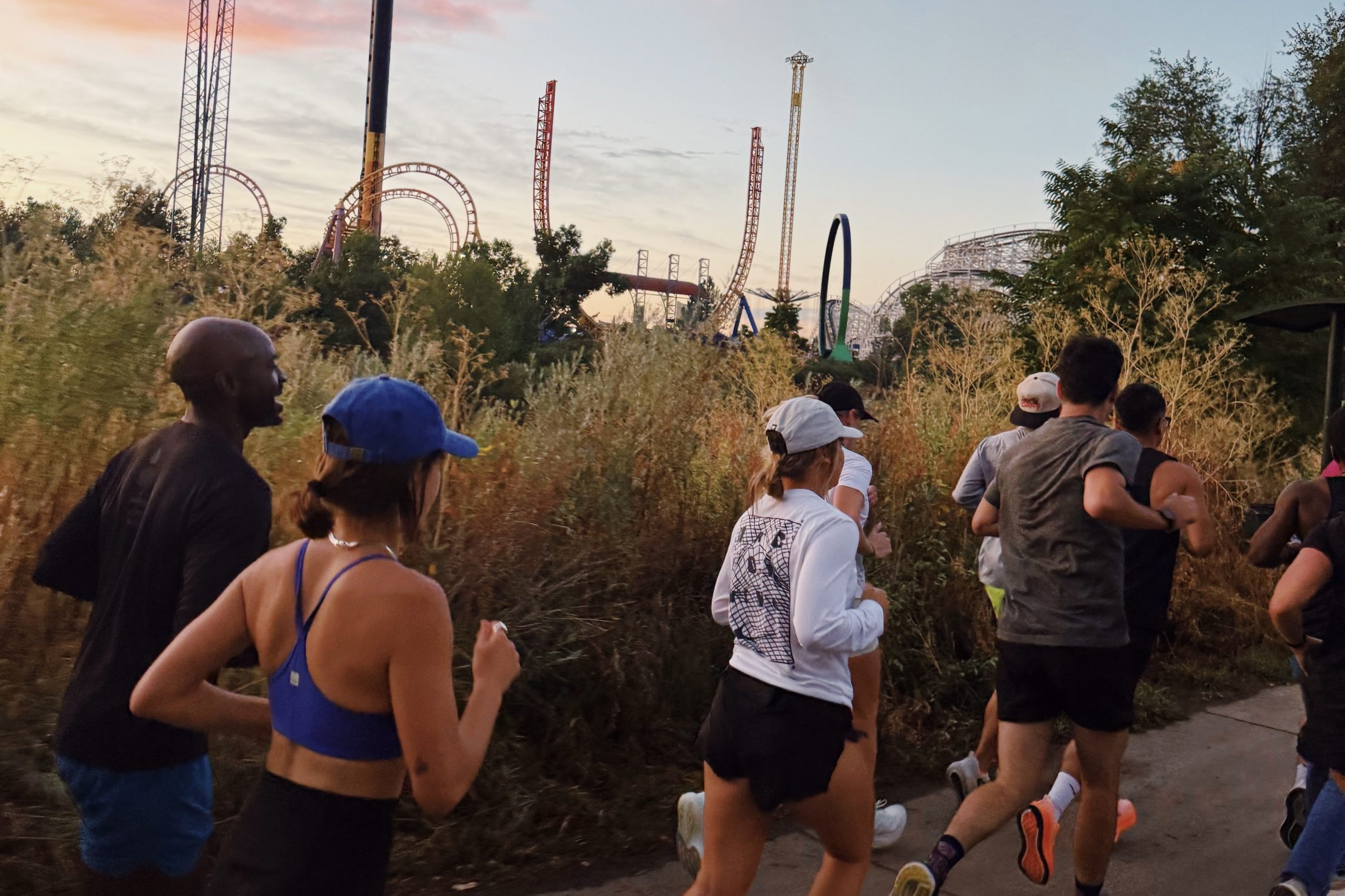 Sexc Pace run club backdropped by Elitch Gardens at sunset