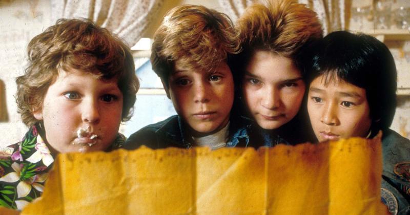 four boys look at treasure map.