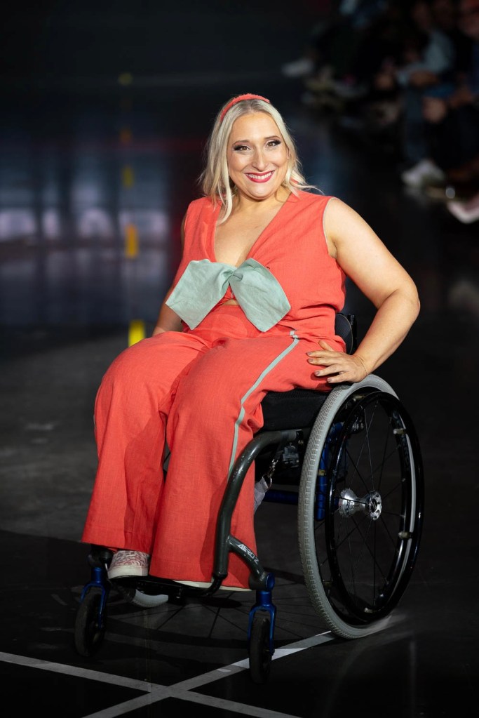 A model in a wheelchair rolls down the runway at Denver Fashion Week