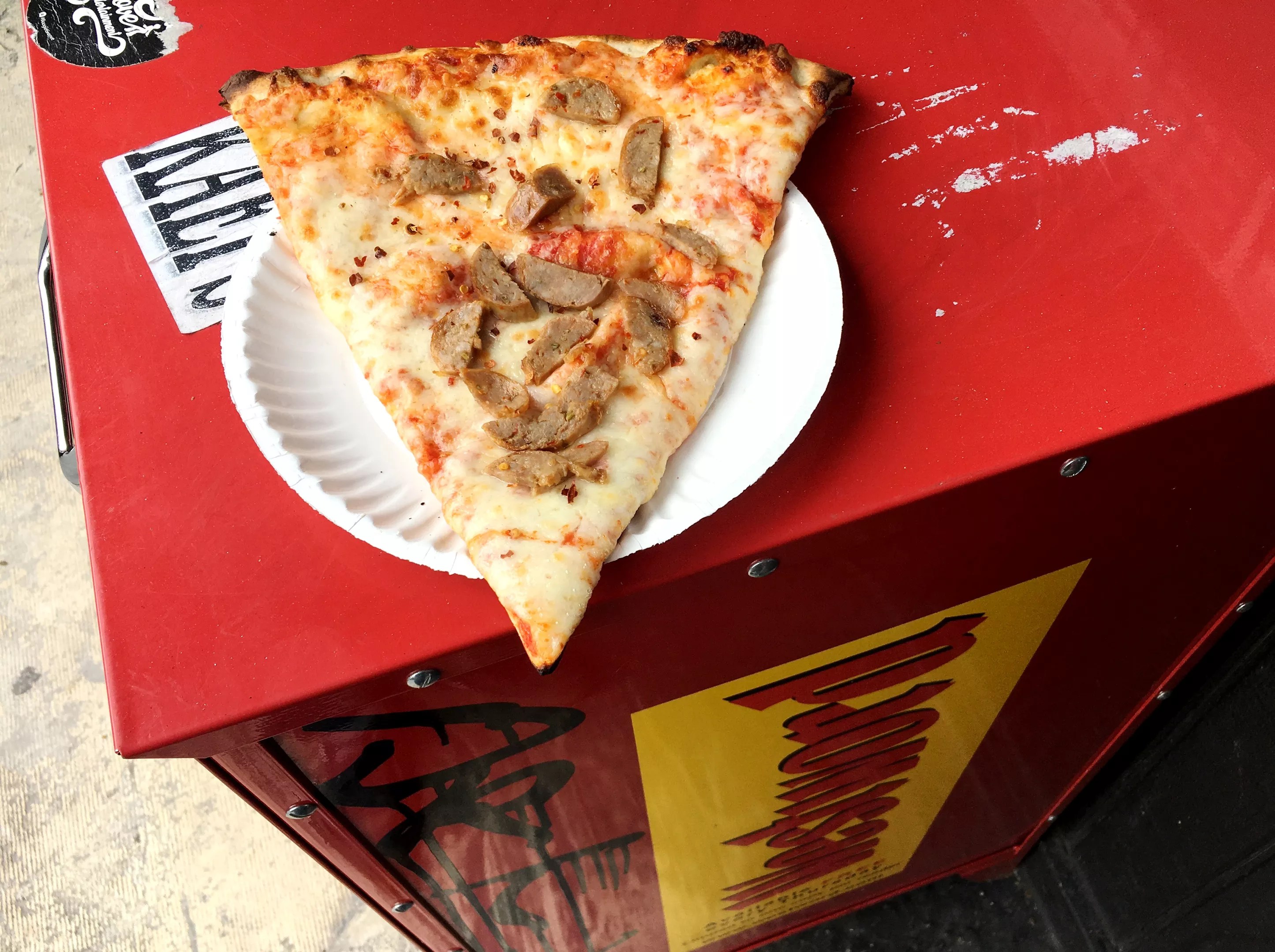 slice of pizza on newspaper box