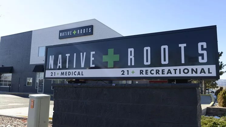 A marijuana dispensary store sign with a green cross