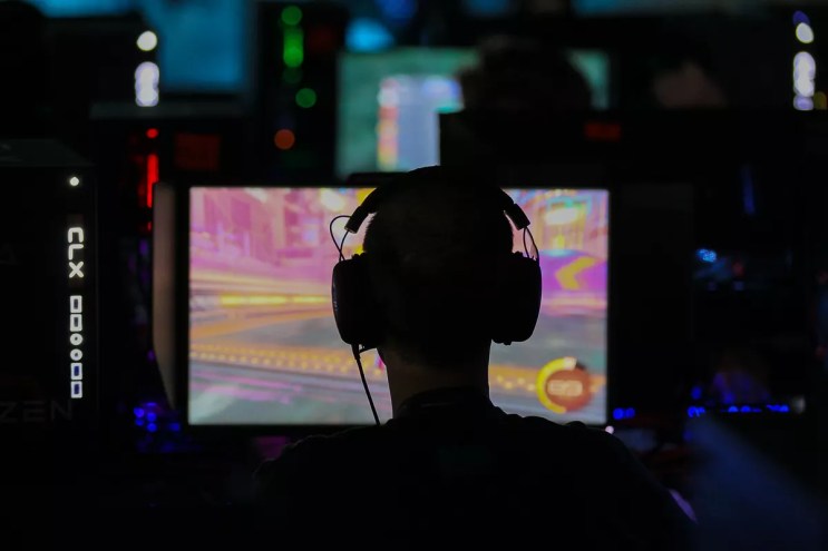 Man in headphones plays video games in the dark