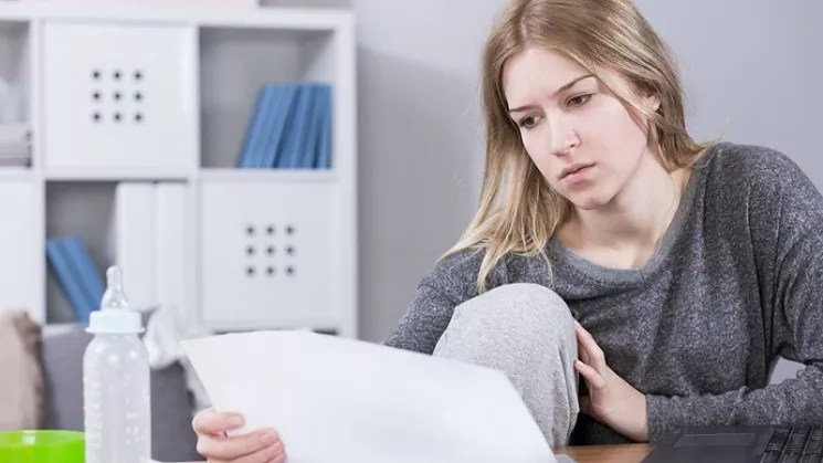 A woman reading a bill.