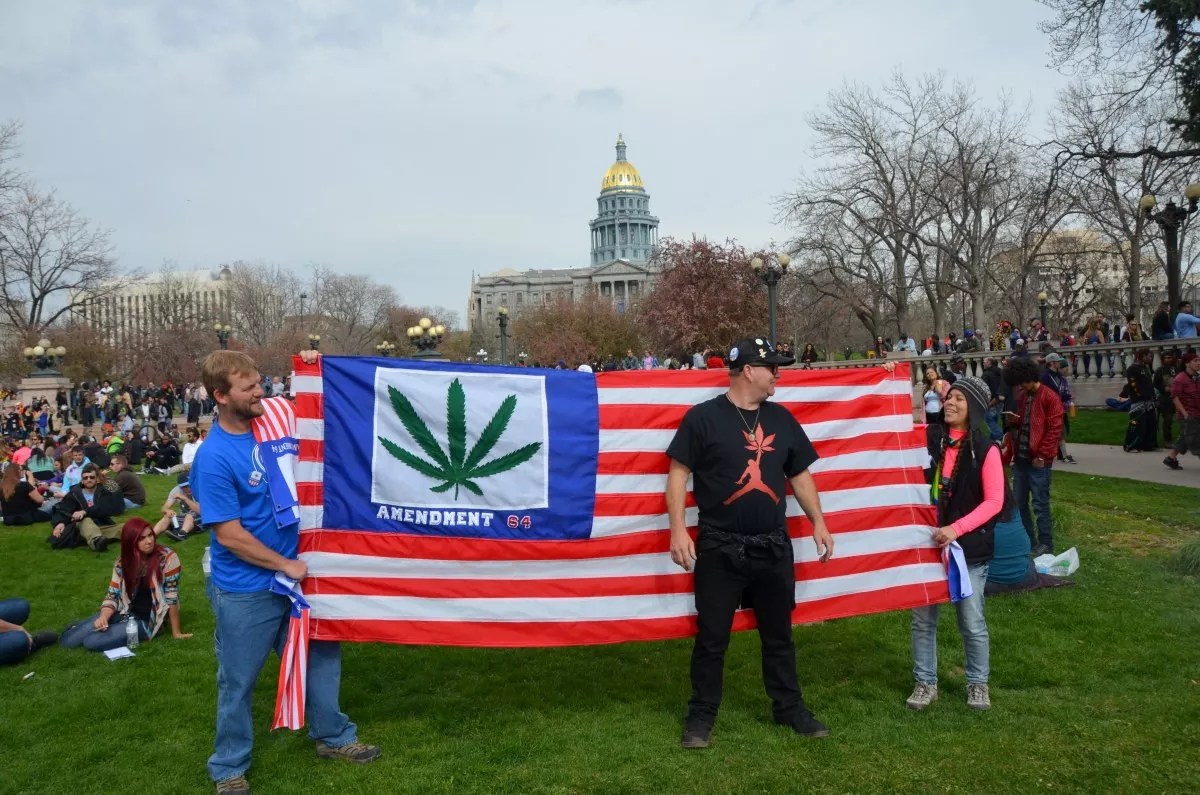Cannabis protesters hold a marijuana flag in Civic Center Park