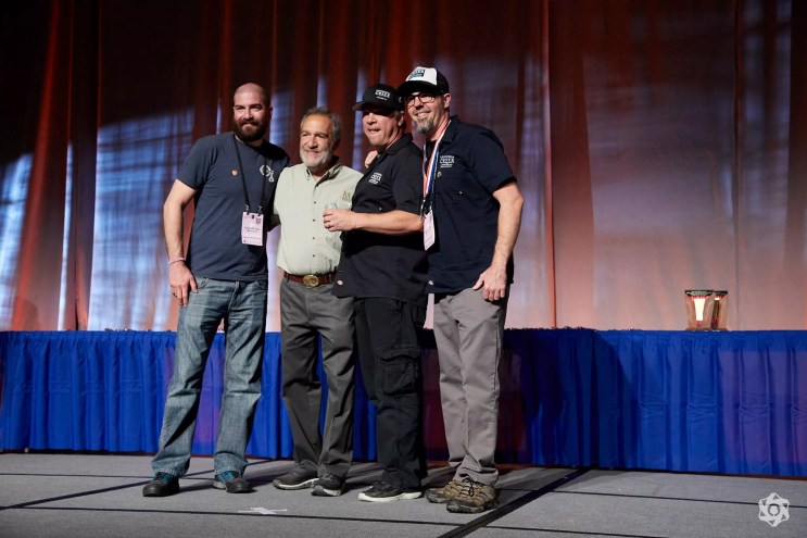 four men standing on a stage