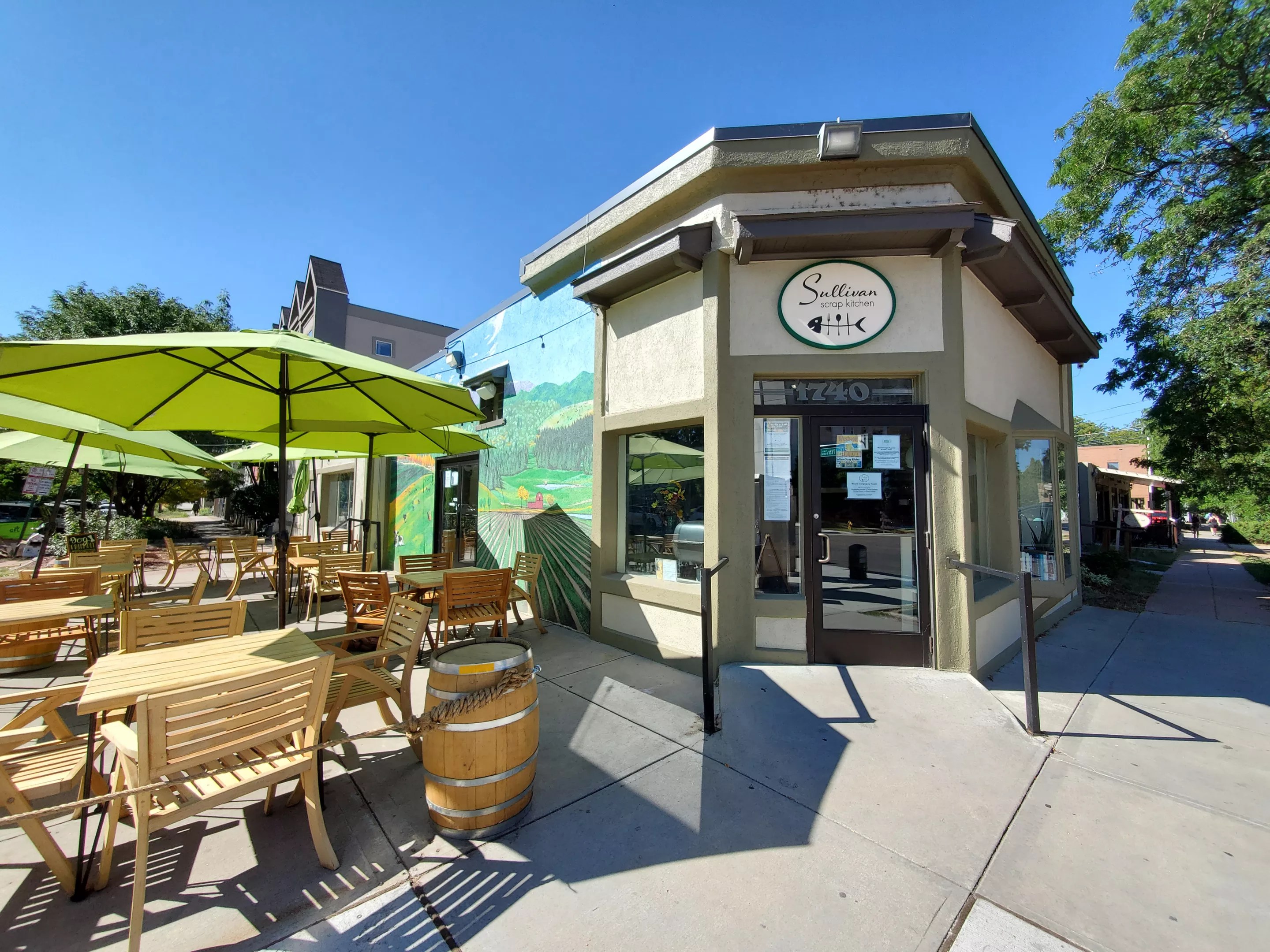 front of a restaurant with green umbrellas in front