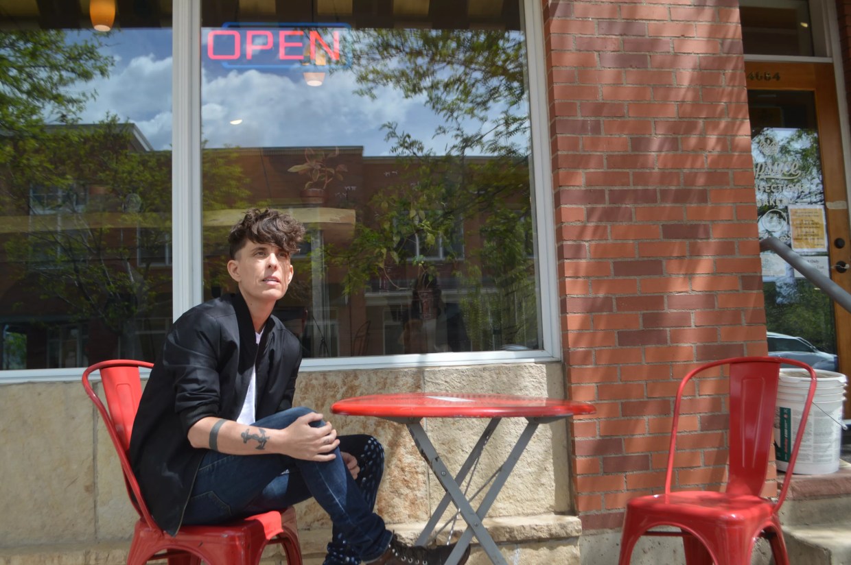 Andrea Gibson sits at a red table