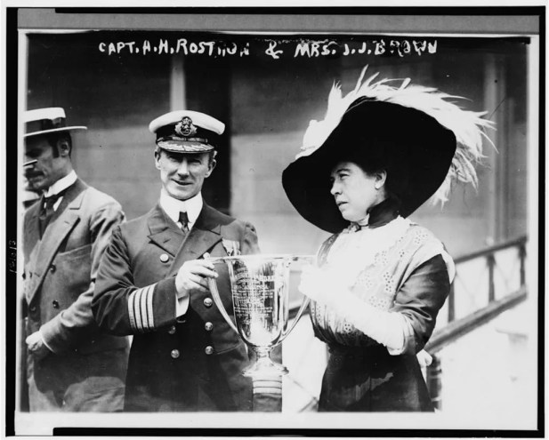 A black and white photo of a woman with a trophy