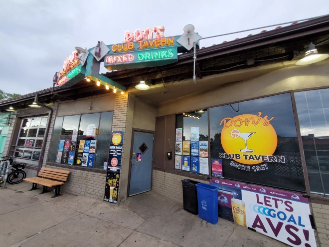 the front of a bar with a neon sign