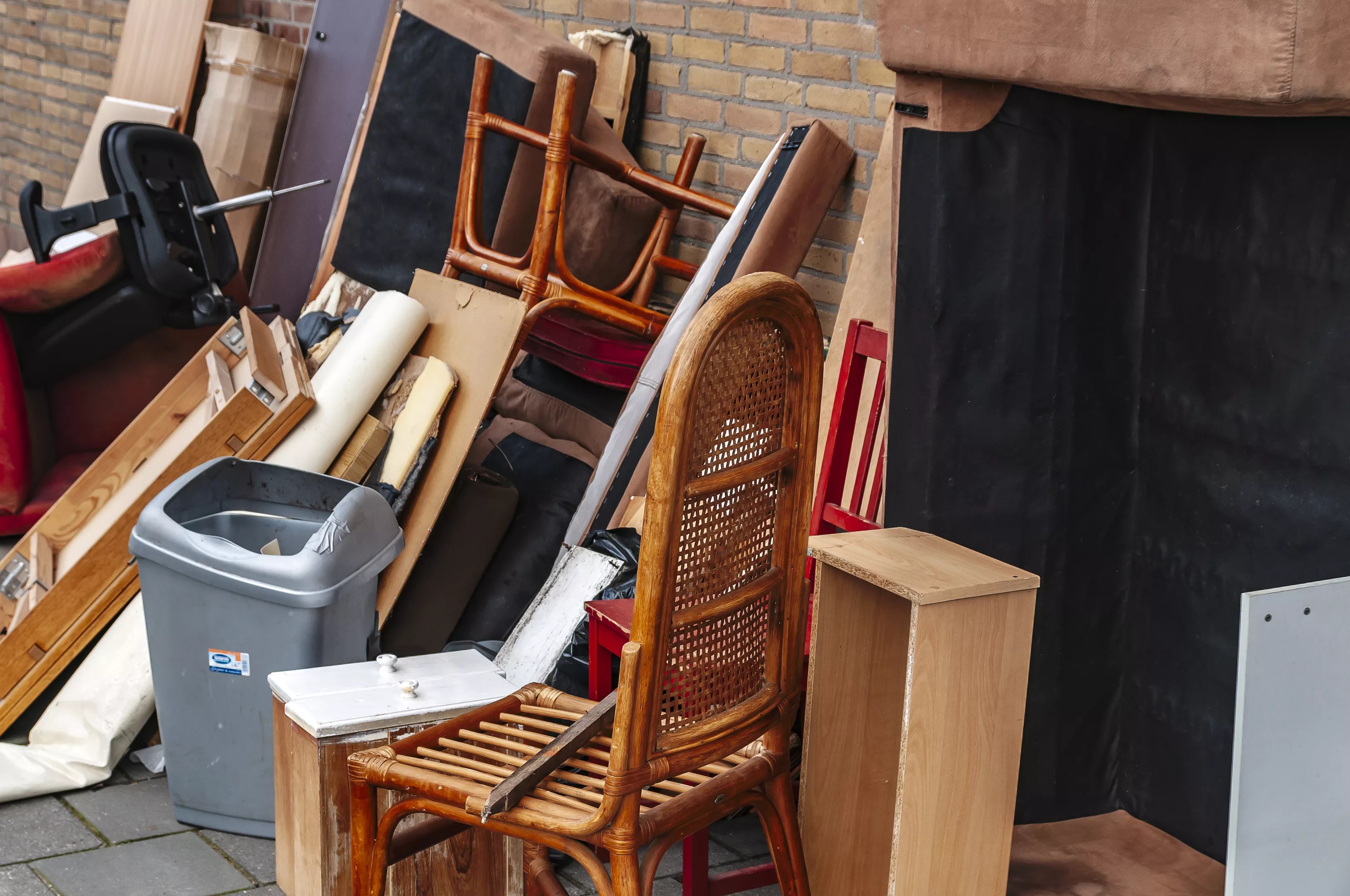 A pile of belongings including chairs and boxes sits amuck.