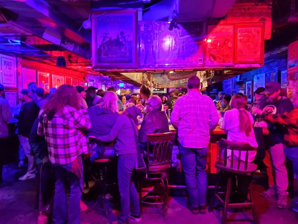 People drink inside a crowded bar