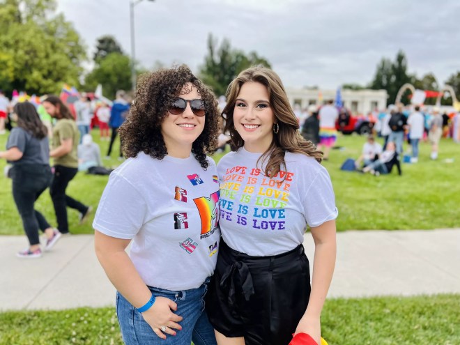 two women wear pride shirts