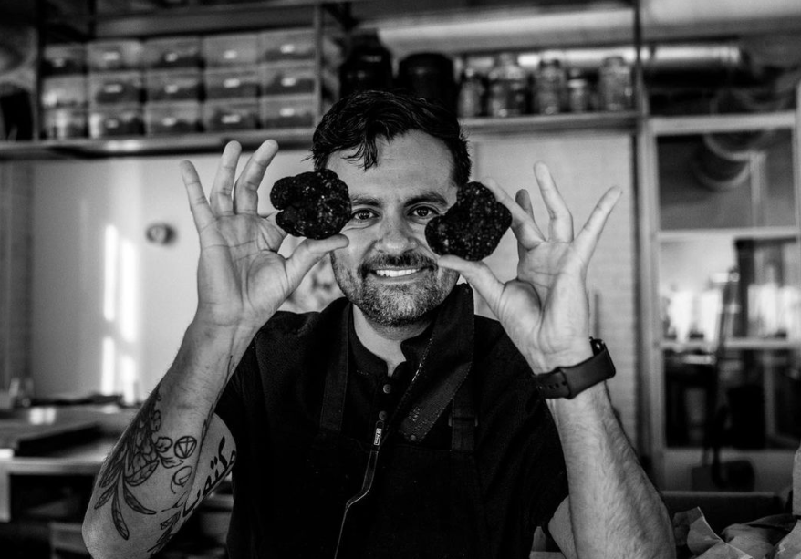 a man holding black truffles