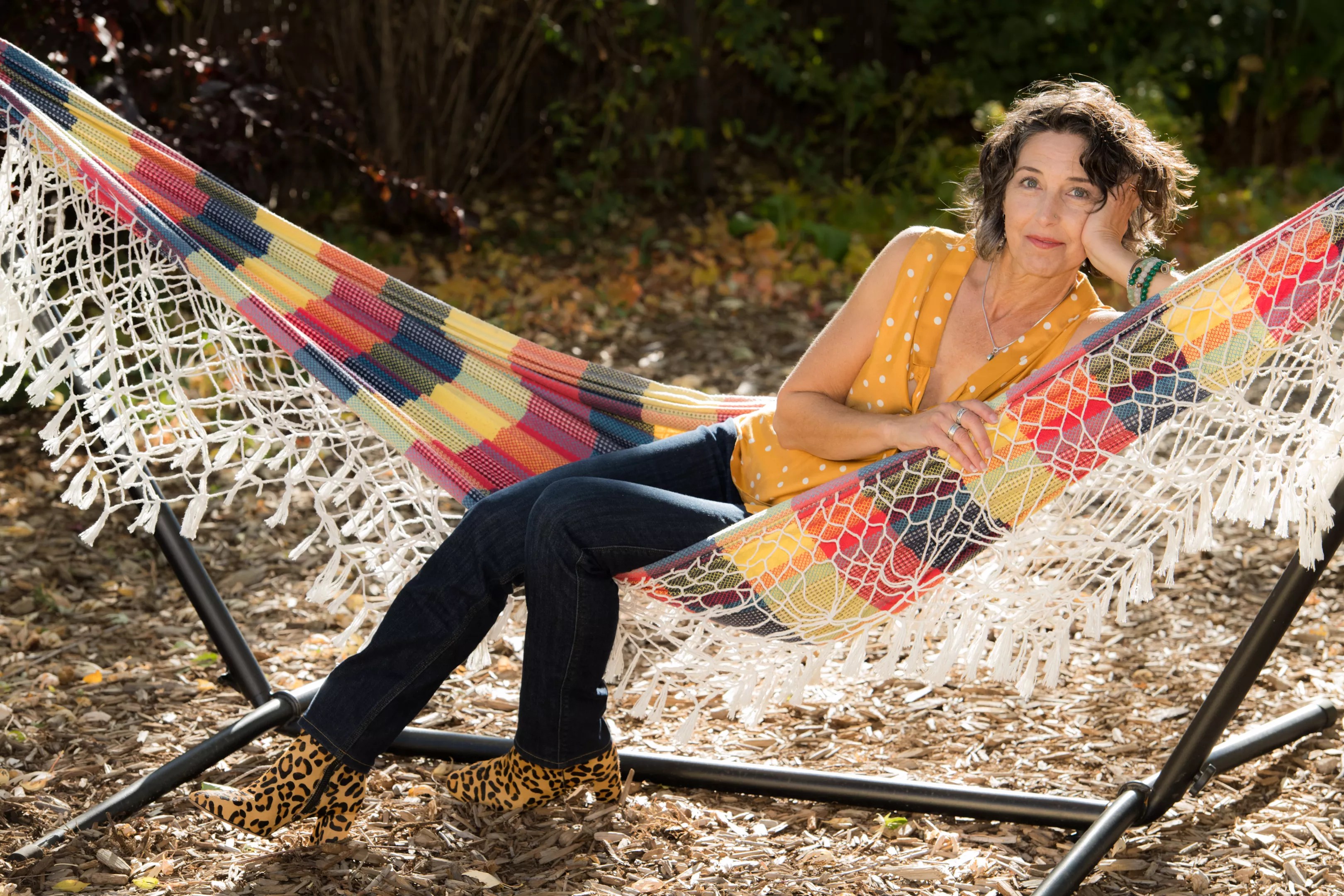 Life coach and Colorado author Amrita Rose reclines in a plaid hammock.