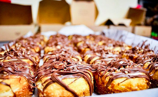 a close oup of mini cheesecakes with chocolate drizzle