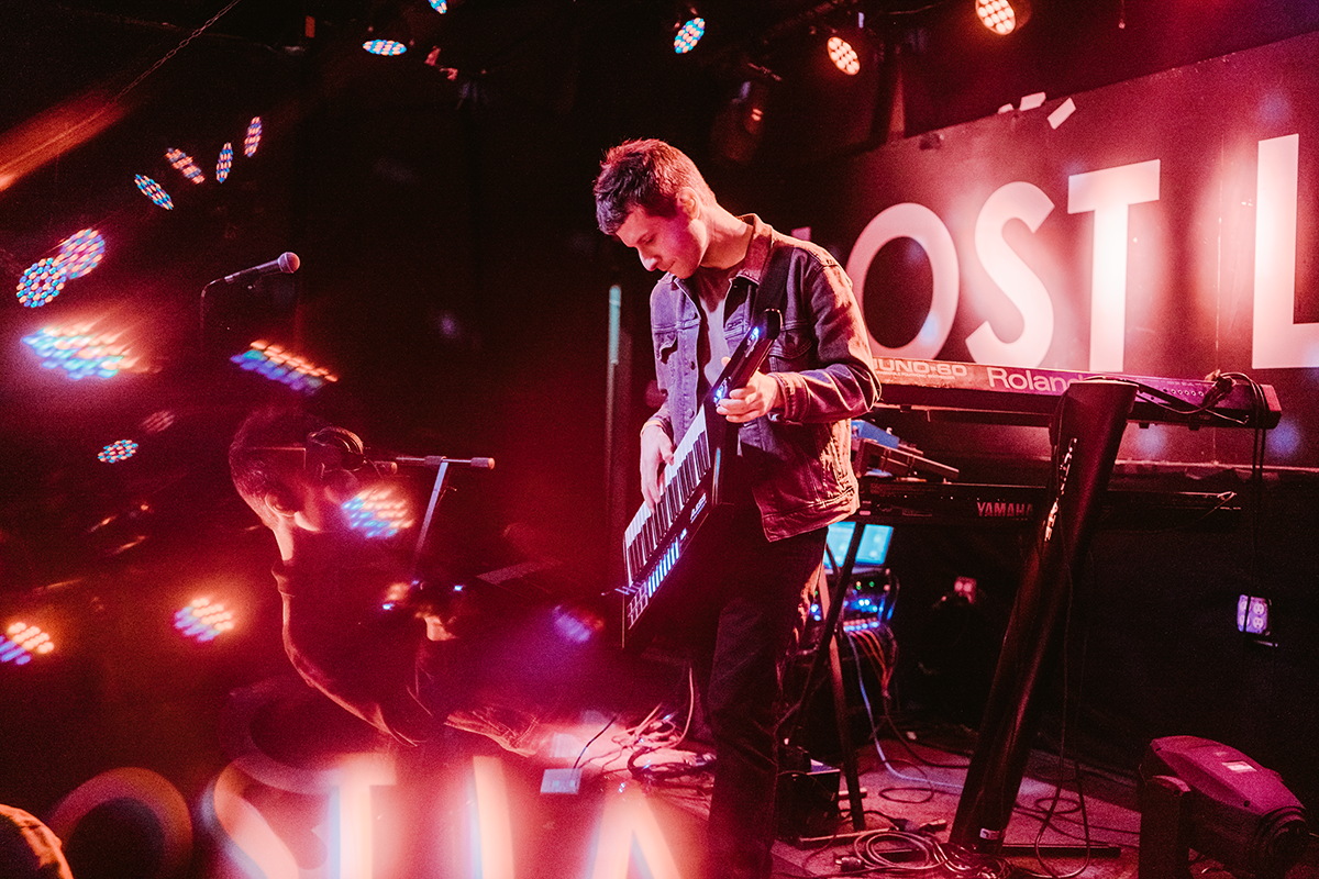 a musician plays a keytar on stage