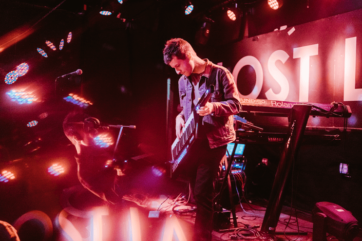 a musician plays a keytar on stage