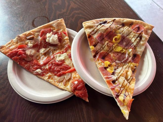 two slices of pizza on paper plates