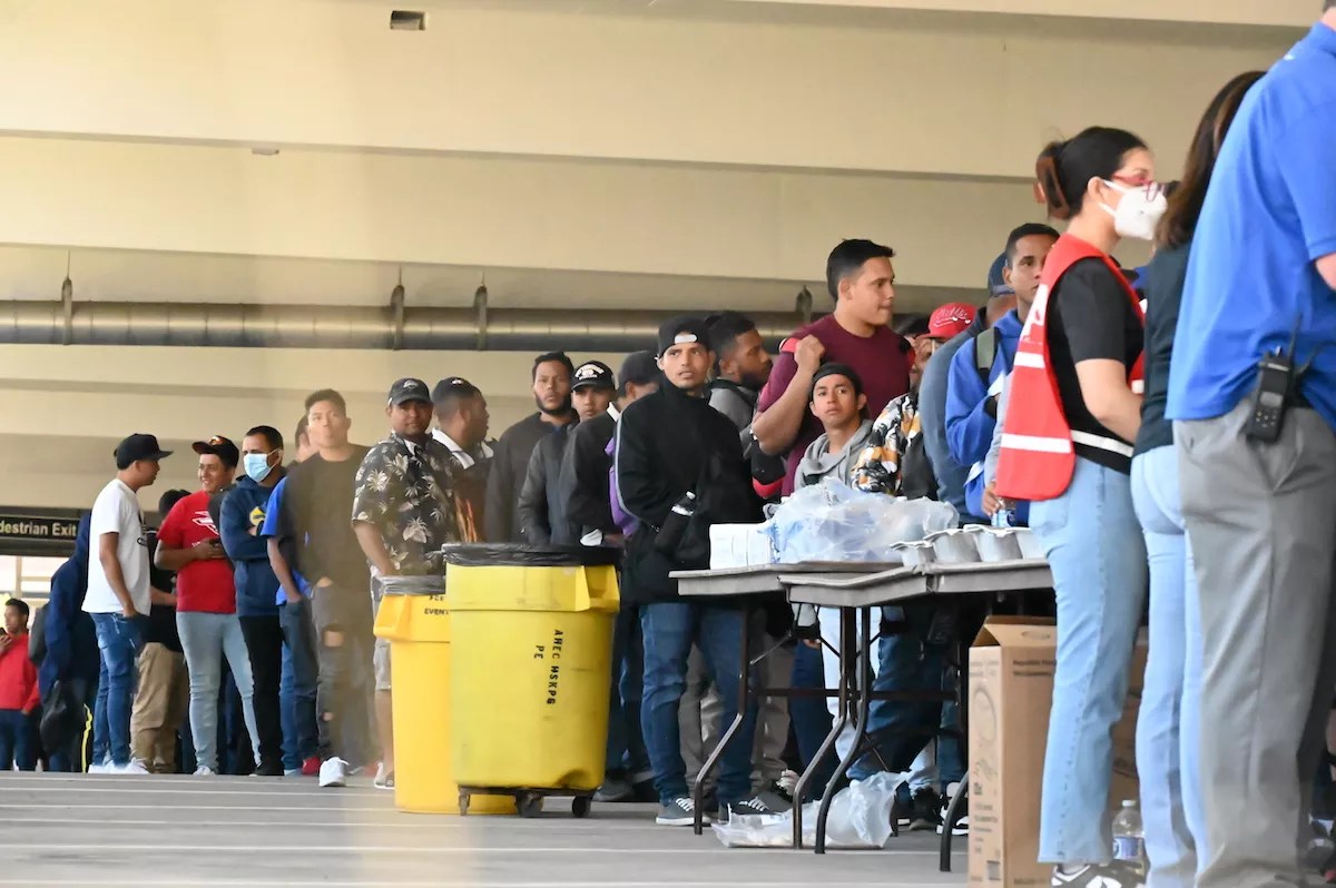 A group of migrants waiting in line for food at the 5th Street Garage on the Auraria Campus in Denver, Colorado.
