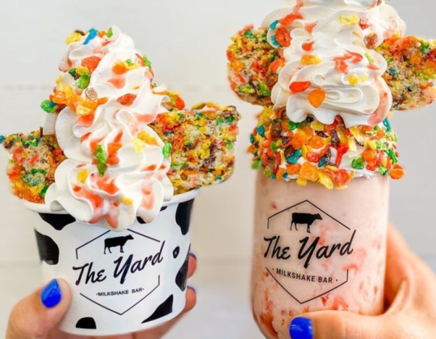 an ice cream sundae and a milk shake topped with lots of whipped cream and toppings