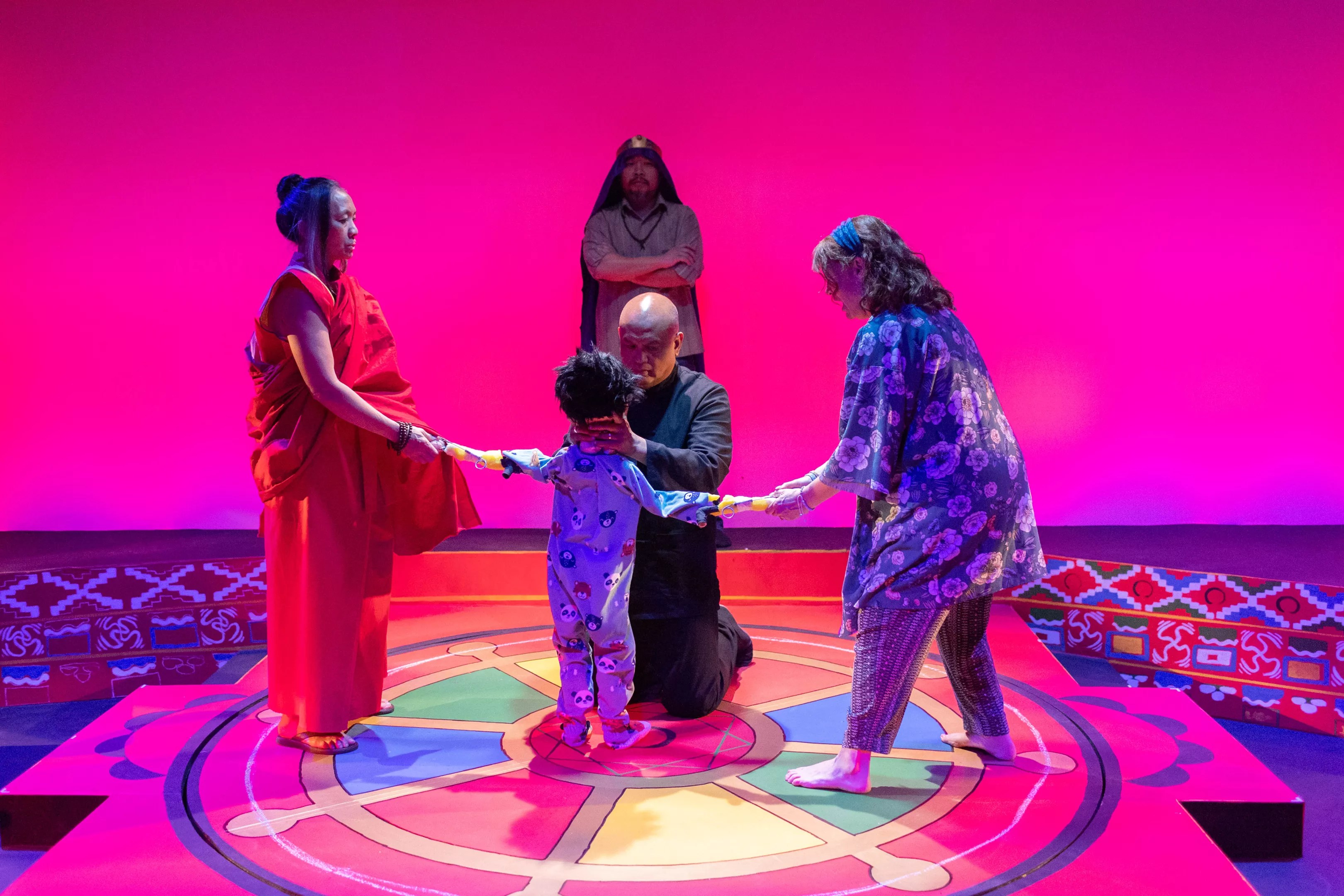 four people in a pink room standing in a circle
