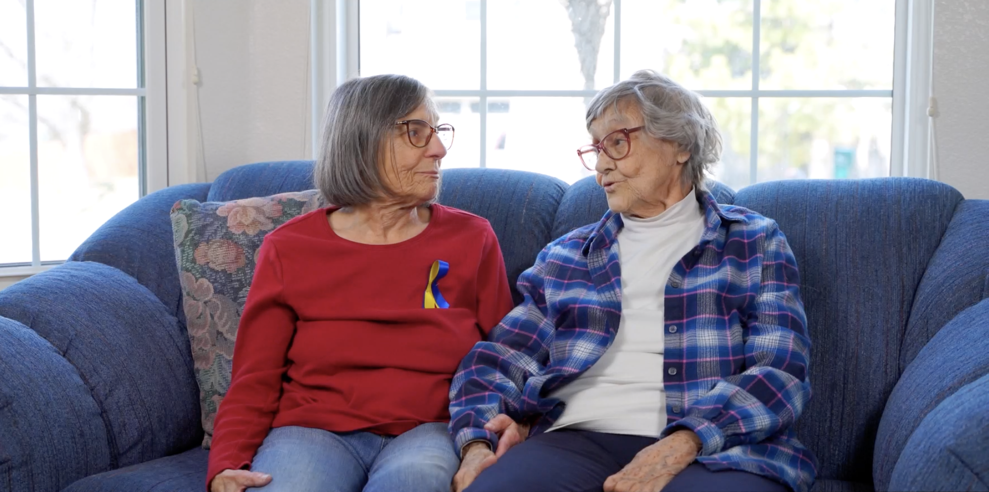 two elderly women speak with each other