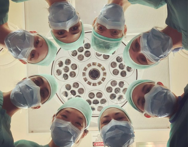A group of medical professionals prepare a person for surgery.