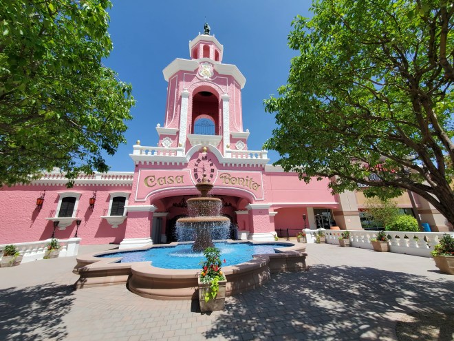 a pink building with a flowing fountain out front