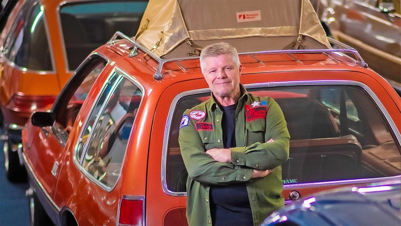 man in front of car in auto museum