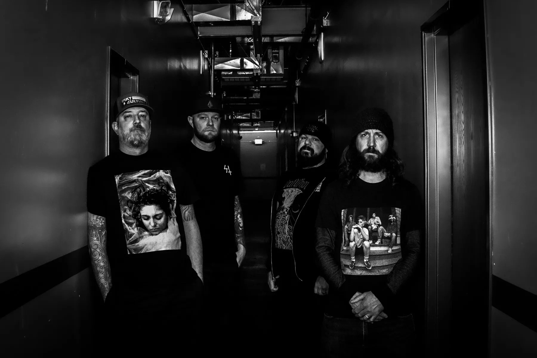 metal bandmates stand next to each other in black-and-white photo