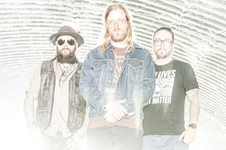 three metal bandmates pose for a photo