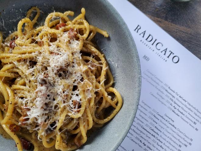 a plate of pasta on top of a menu