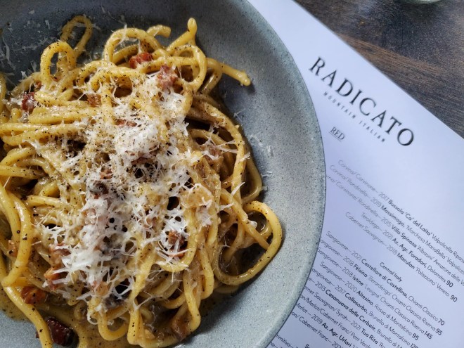 a plate of pasta on top of a menu