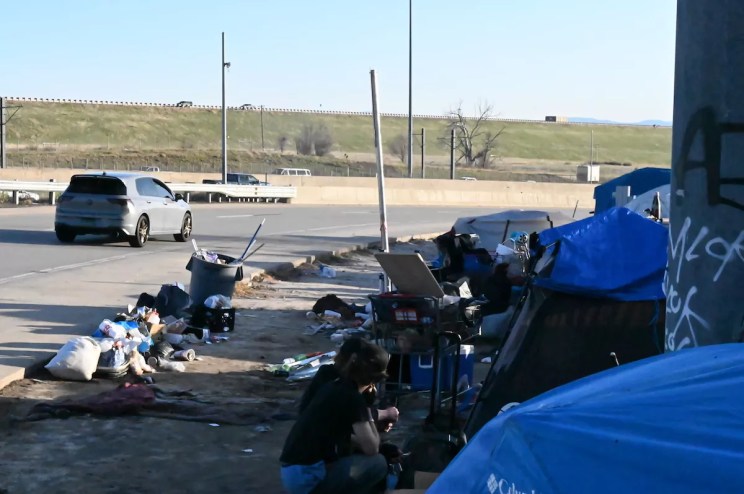 A homeless encampment sits next to Interstate 225 and Parker Road, a popular route through Aurora to Denver.