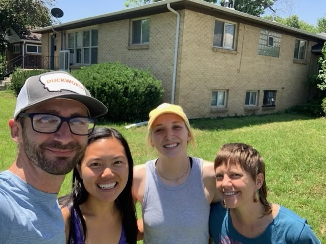 four people outside the building they bought together.together