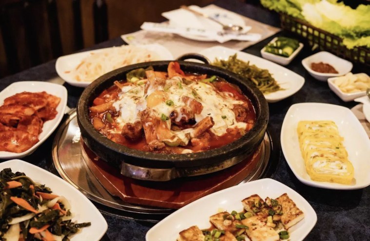 a variety of dishes on a table on plates and in bowls
