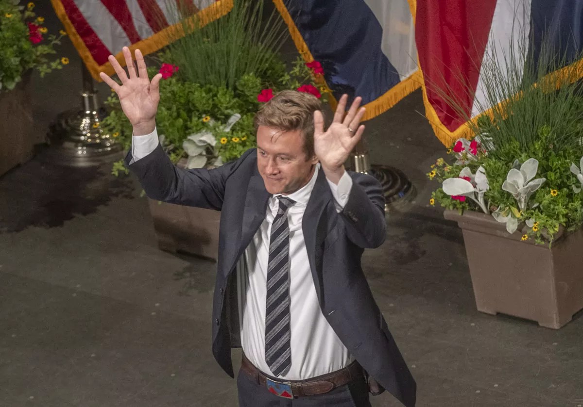 new mayor in tie raises hands