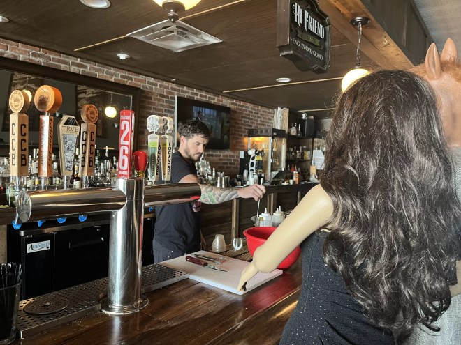 a man behind a bar mixing a drink
