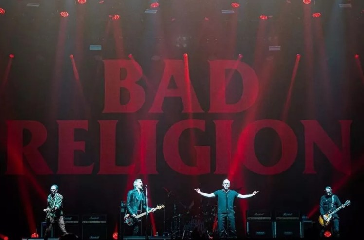 band on stage with red lettering spelling bad religion in the background.