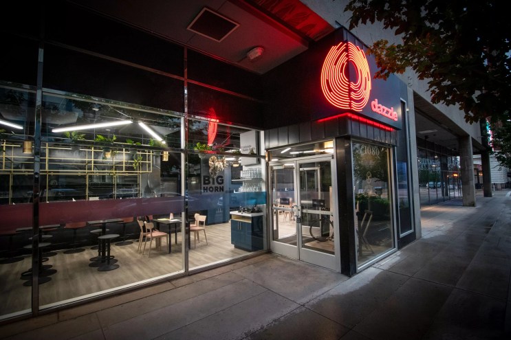 the exterior of a club with red lettering spelling "dazzle."