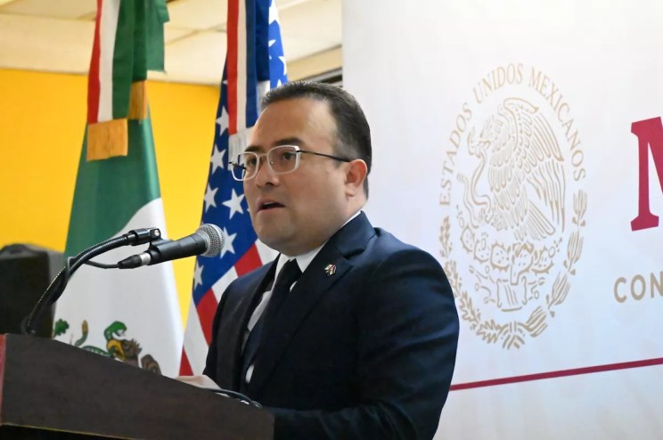 Mexican Consul General in Denver Pável Meléndez Crus speaks in front of the Mexican and American flags.